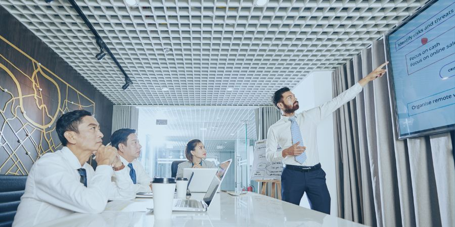 4 employees in an office looking at a screen showing how to build a crisis plan