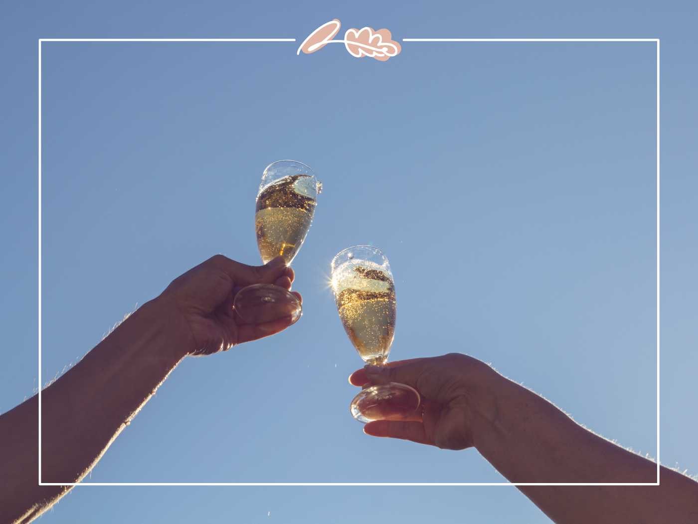 Two hands toasting with glasses of champagne under a clear blue sky, celebrating a joyous occasion - Fabulous Flowers and Gifts.