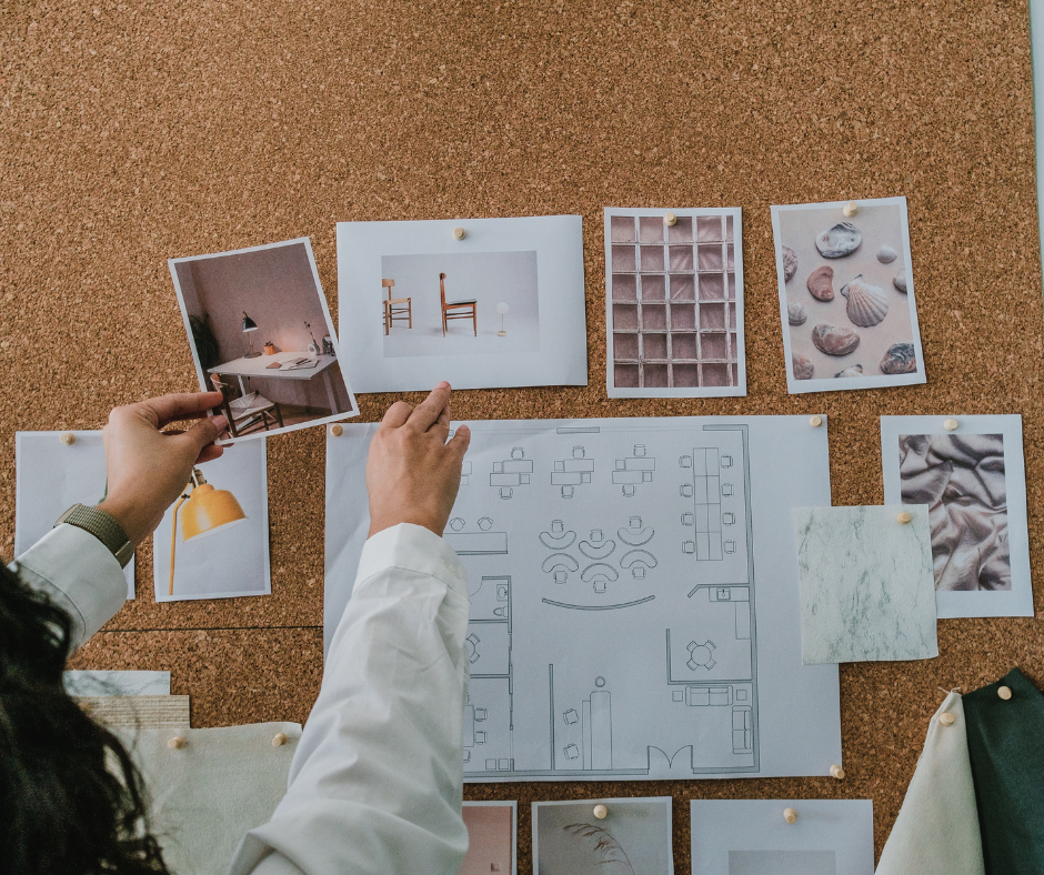 a woman pins interior design images to a cork board above a blueprint