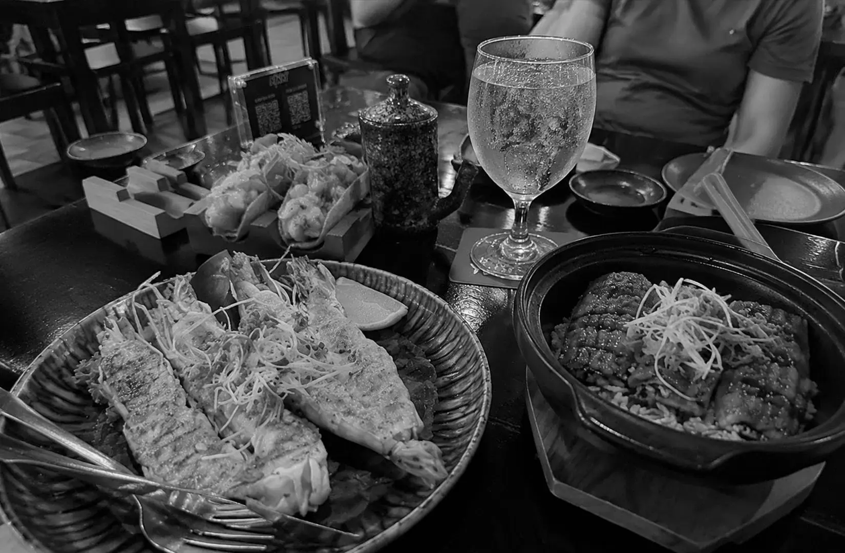 Japanese-inspired seafood dishes served with rice and appetizers at a restaurant table.