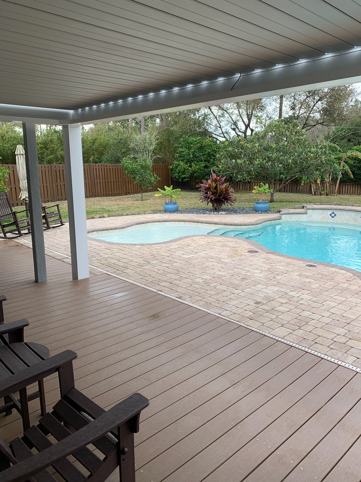 Pool side pergola with a louvered roof pergola kit.