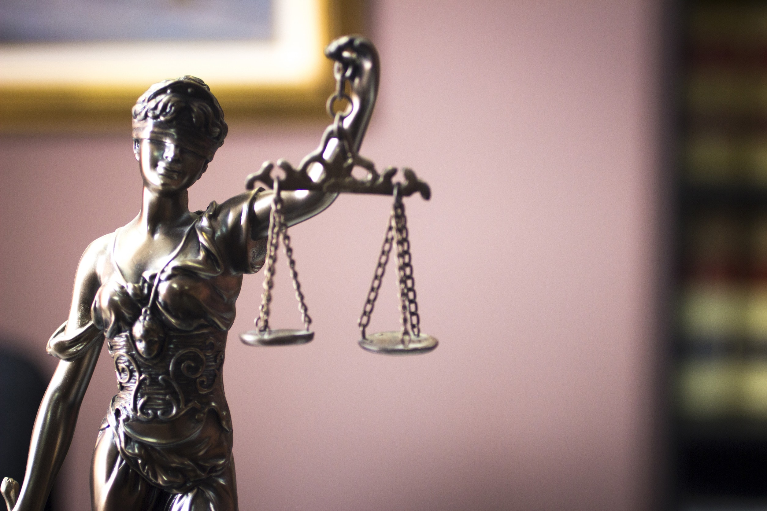 A bronze statue of lady justice in a court room