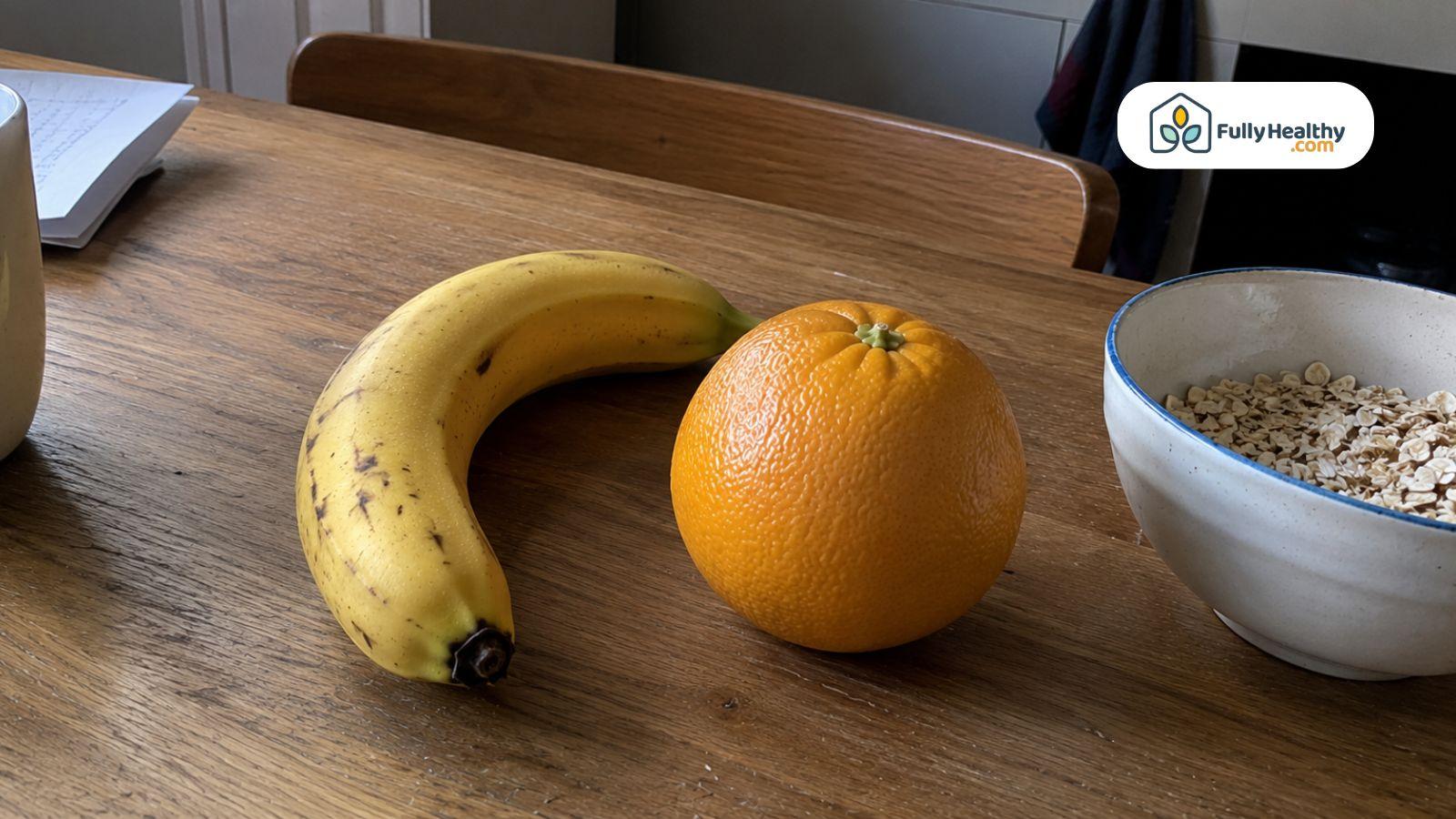 Banana and orange beside a bowl of oats for a healthy fiber comparison.