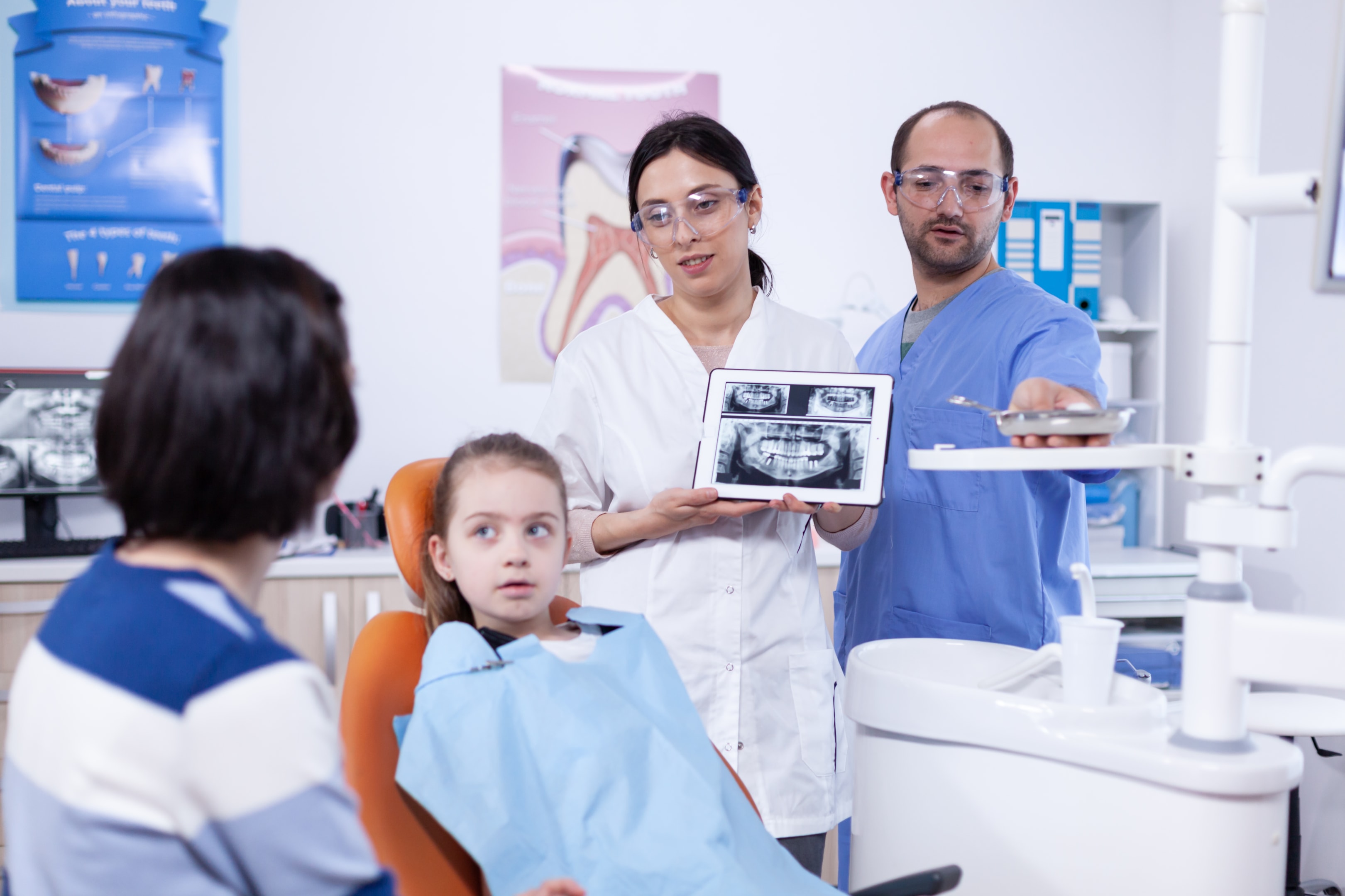 A photo of Mother and daughter together with an oral surgeon.