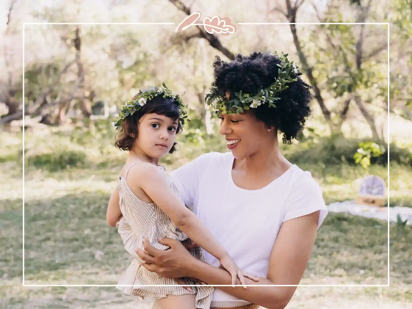 A mother and daughter wearing matching floral crowns, enjoying a day in the park. Mother-Daughter Blossoms Crown Set by Fabulous Flowers and Gifts.