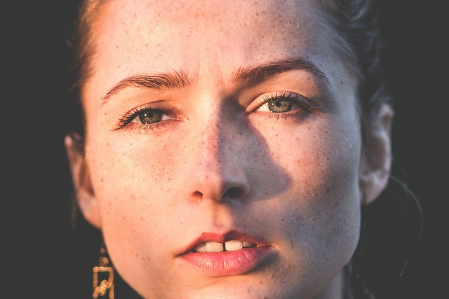 Portrait of a woman's face with freckles on her face but clear of acne.