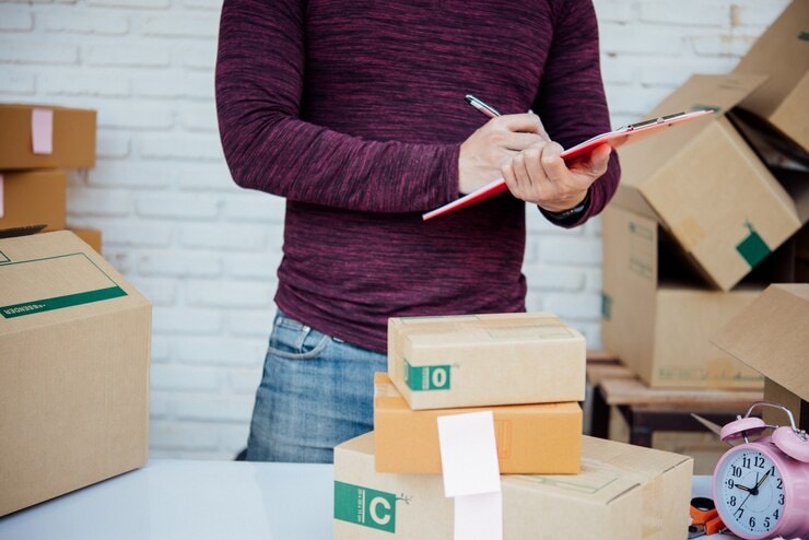man listing box items 