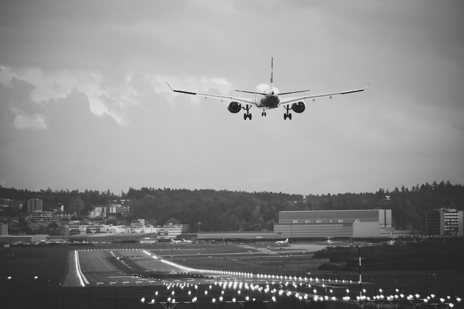 An aircraft landing on an illuminated runway.