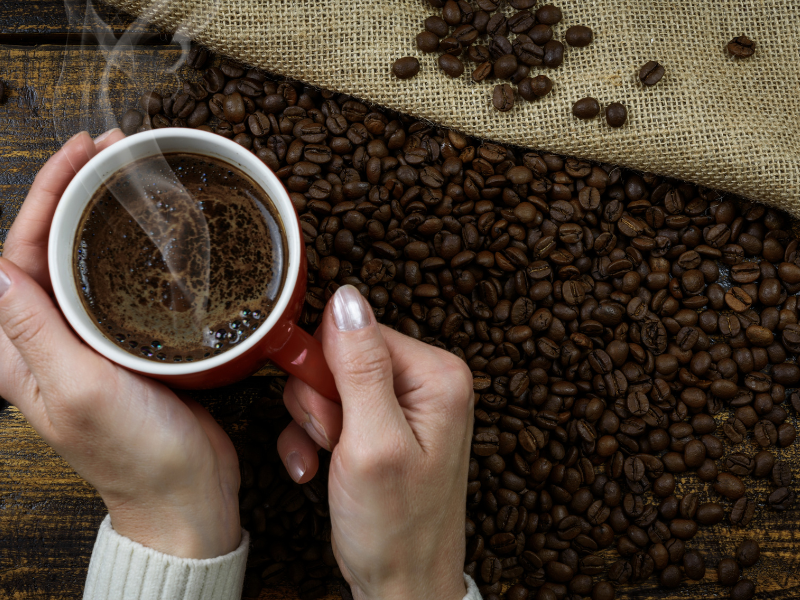 Xícara de café quente e grãos de café. Foto: PhotoMIX-Company de pixabay - Canva