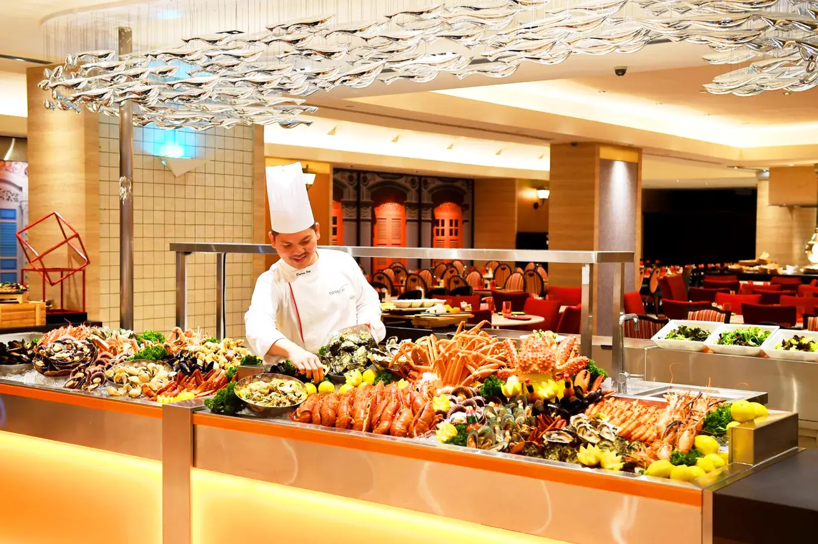Carousel buffet at Royal Plaza on Scotts with premium seafood station and chef preparing fresh shellfish