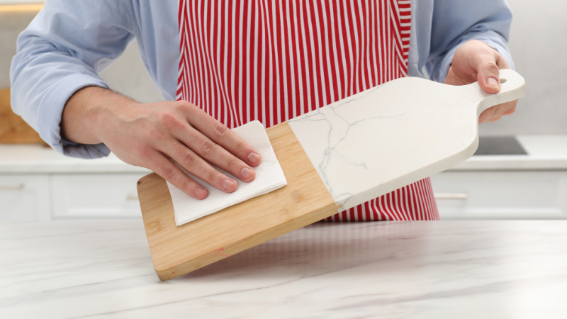 A man is cleaning the cutting board and rubber feet