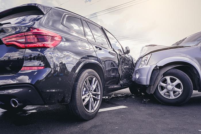 Two vehicles with severe collision damage in a parking lot highlighting the need for a personal injury attorney