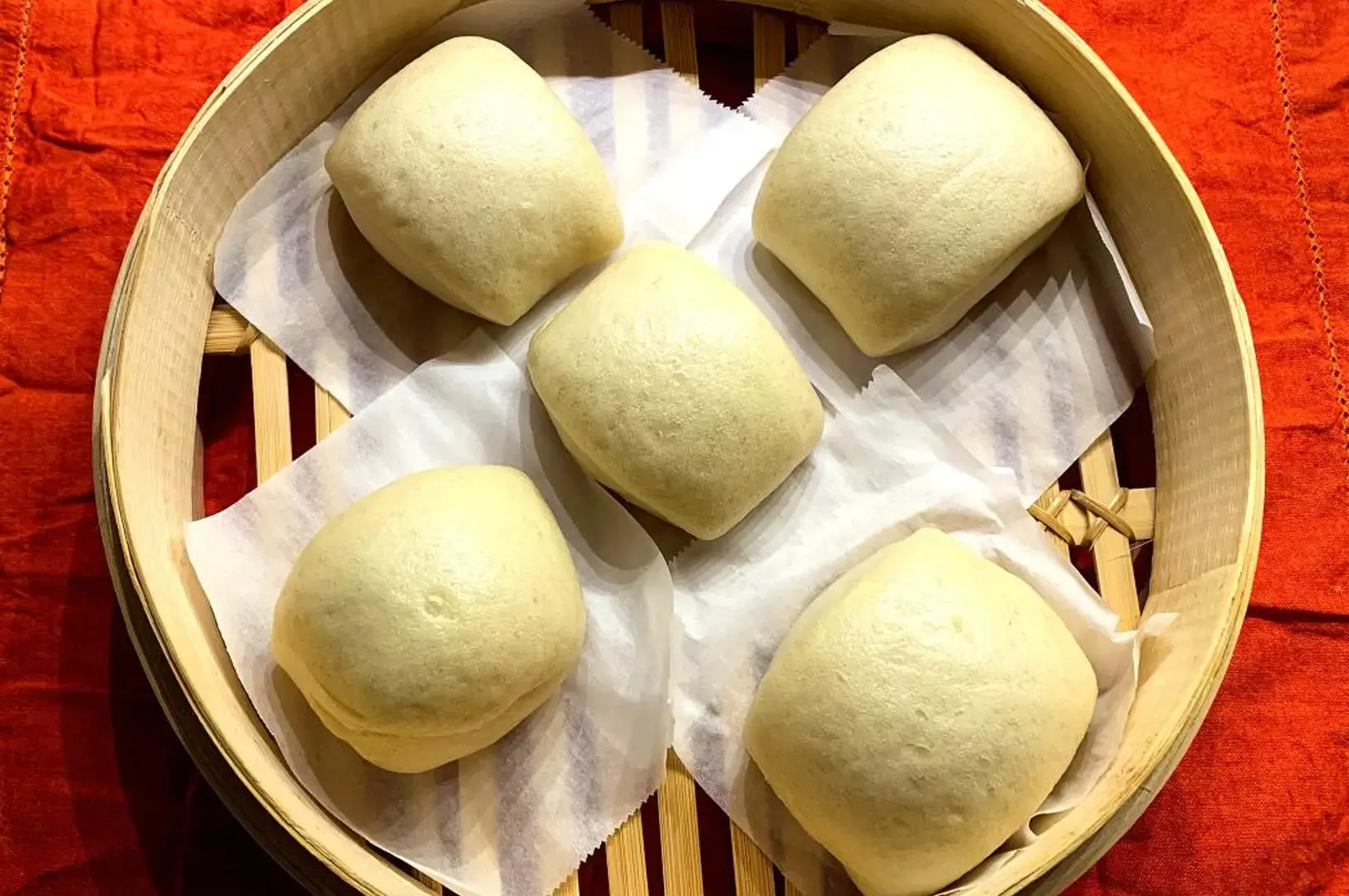Traditional Chinese steamed buns served in a bamboo basket at a Singapore seafood restaurant