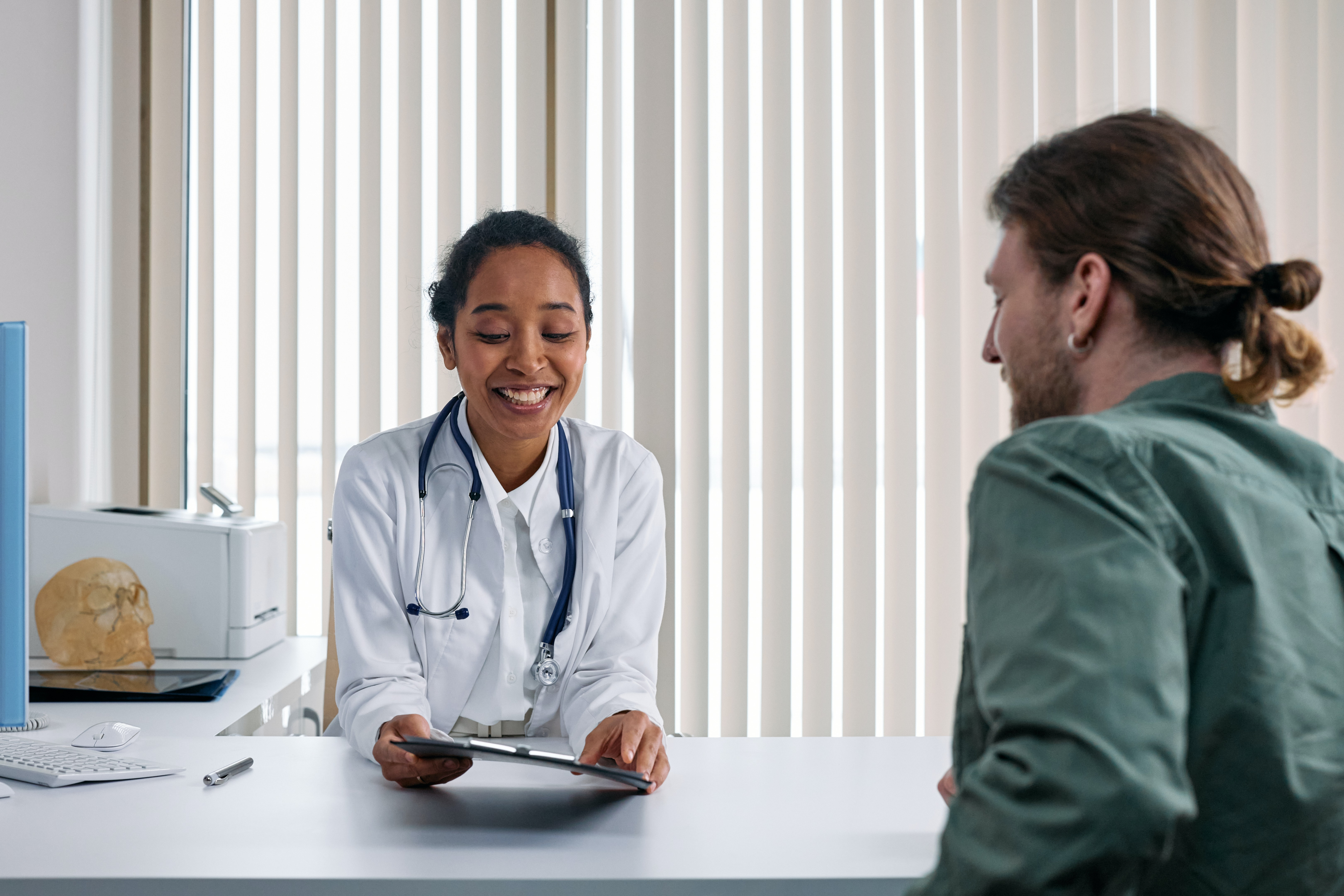 A doctor discussing their notes with their patient.