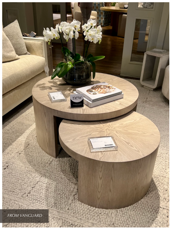 a vignette of nesting tables and scattered home decor objects mixing materials in the living room of a show room