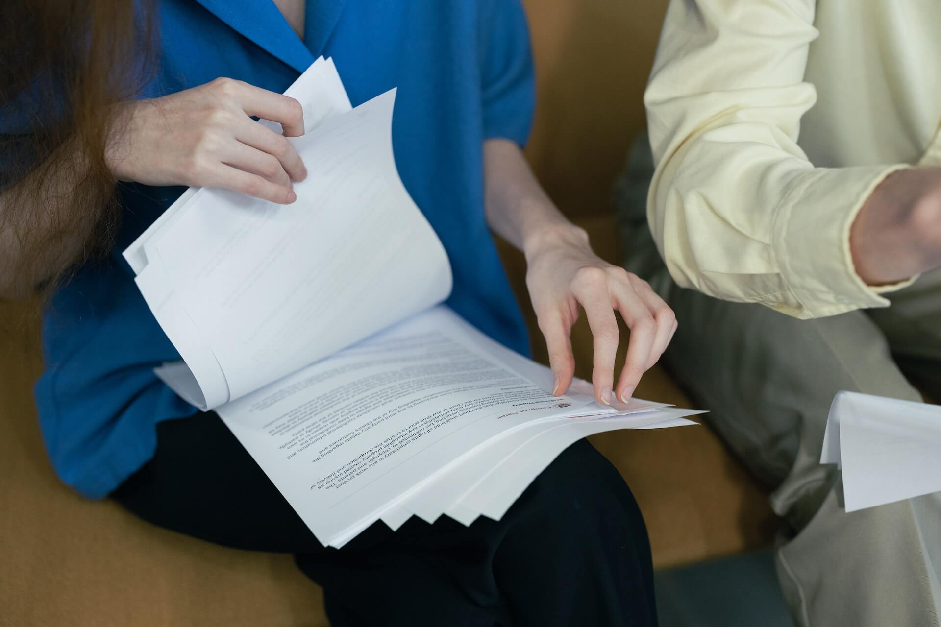 close up of person's hands flicking through paper documents on employee development