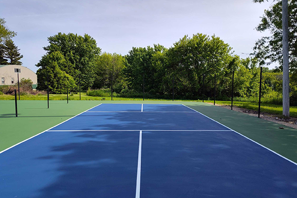 Transformed pickleball courts at Campbell Park in Strawberry Point, IA, featuring vibrant surfaces and clear striping after crack repairs and acrylic resurfacing of former tennis courts.