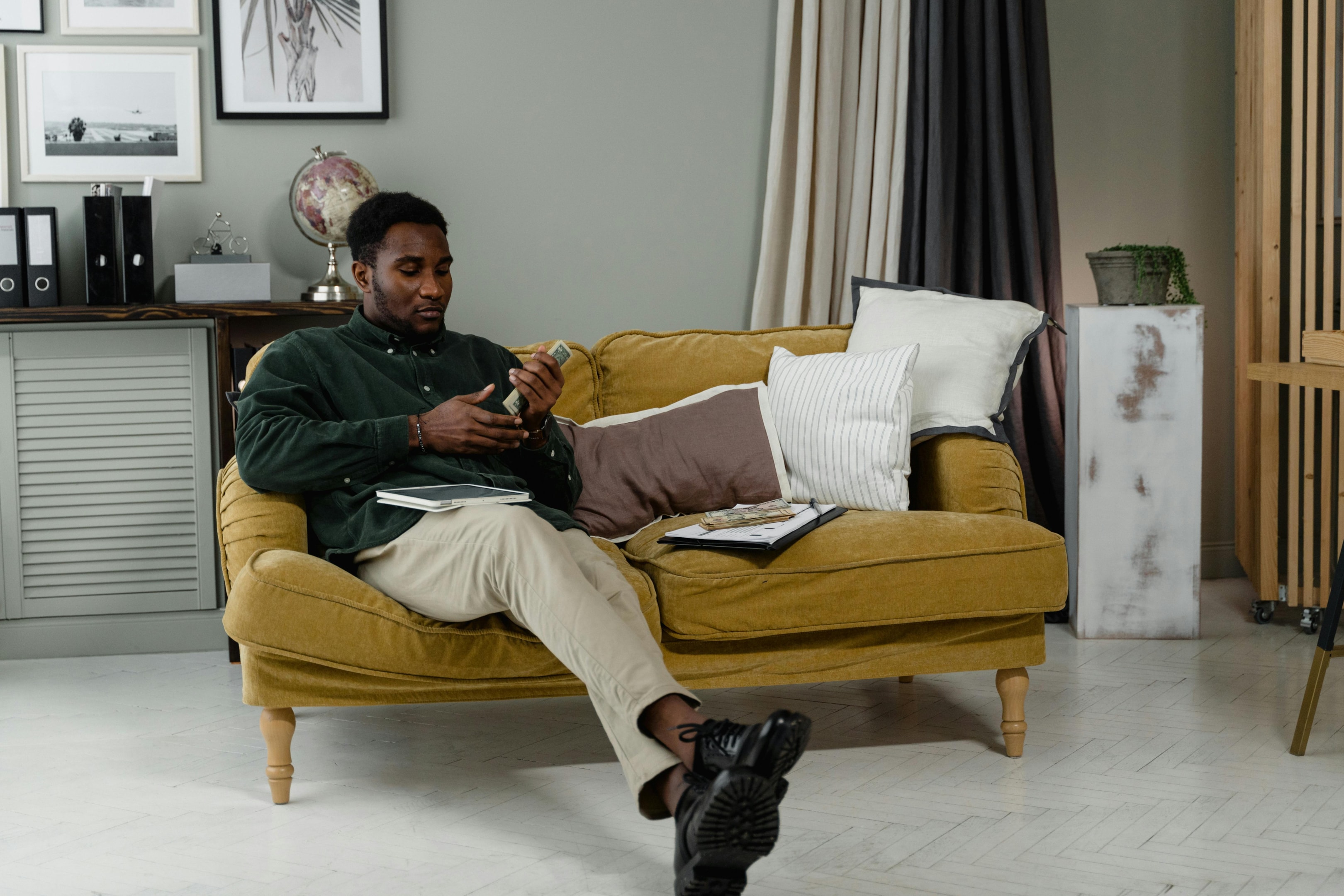 Man on a couch holding his income