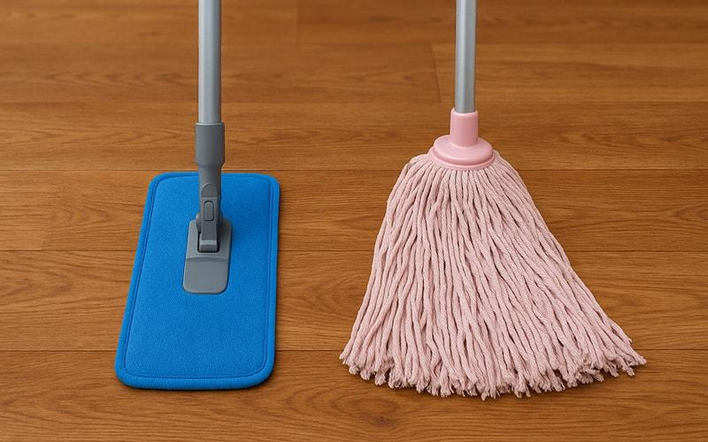 A blue dry mop next to a pink wet mop