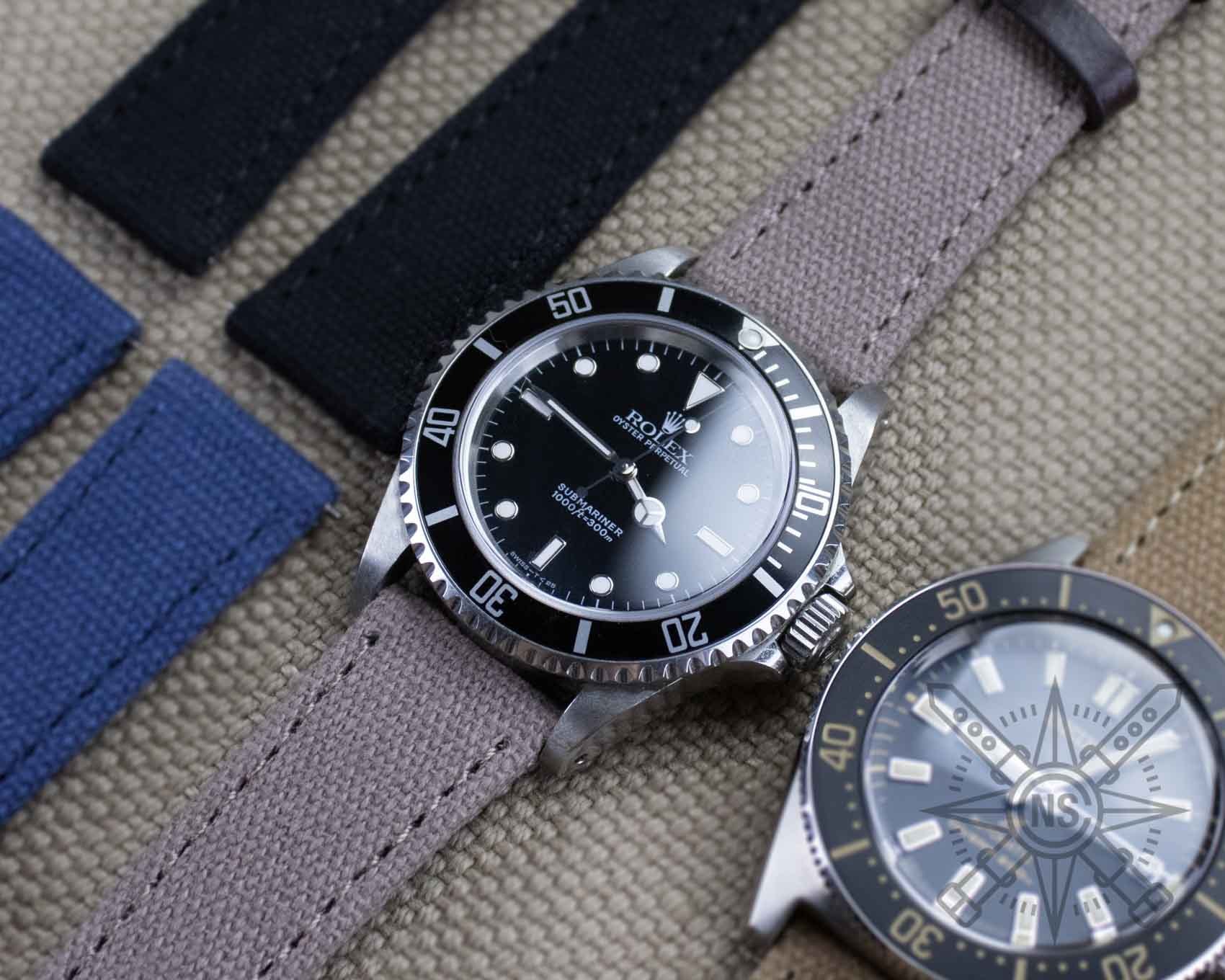 Various styles of canvas watch straps displayed together.