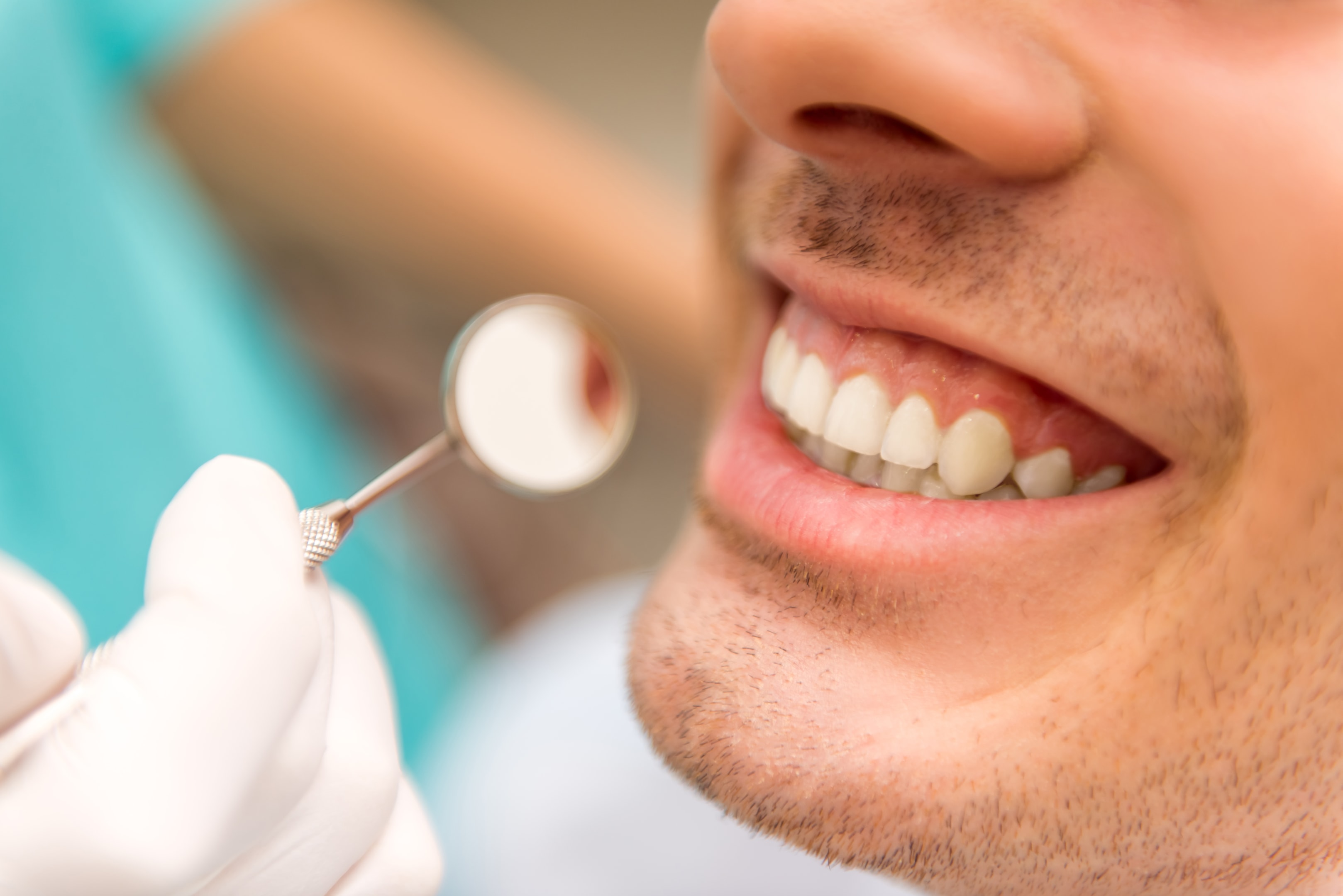 A male patient getting a dental check-up to maintain his dental implant calgary ab