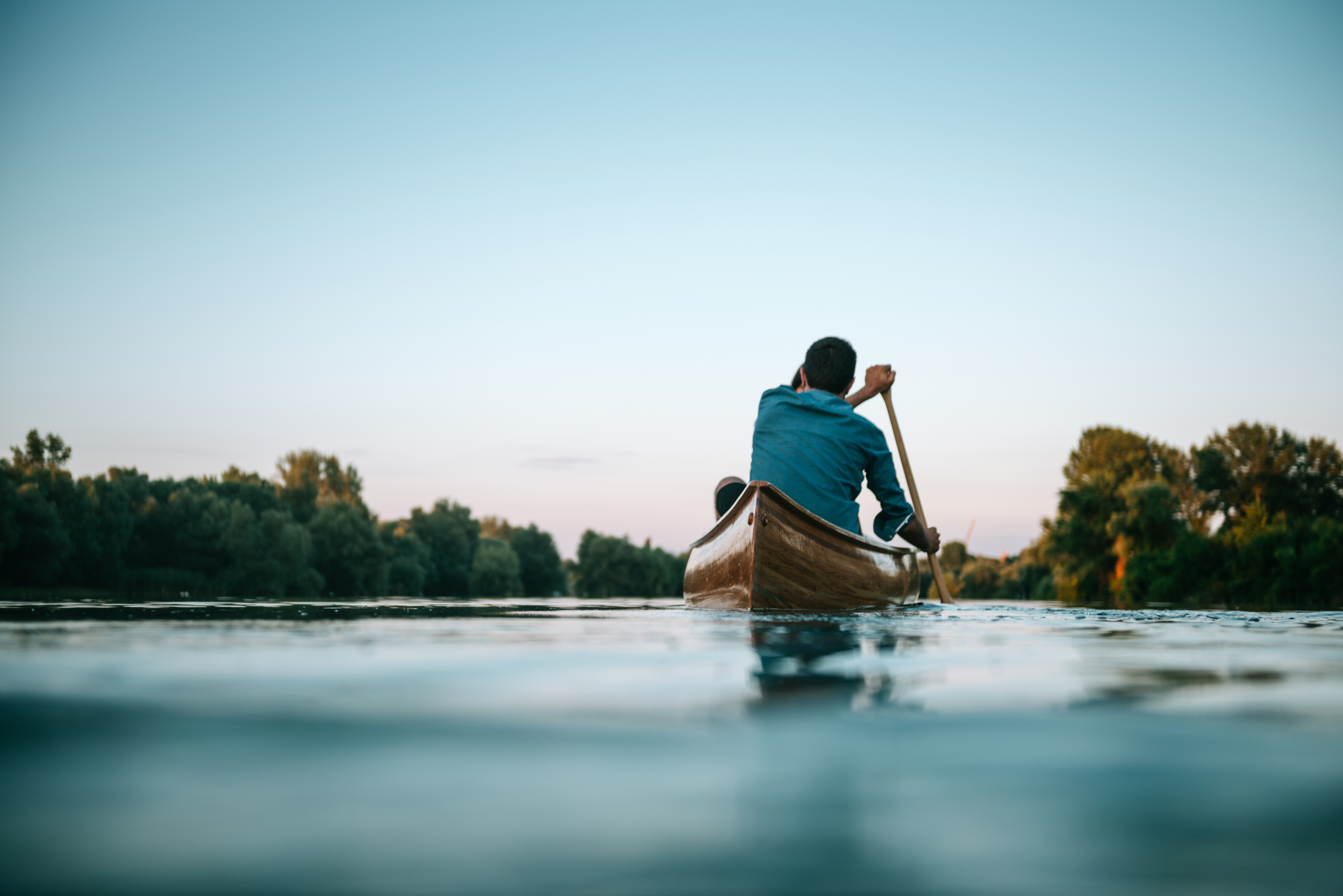 A man on a canoe floating down the lake