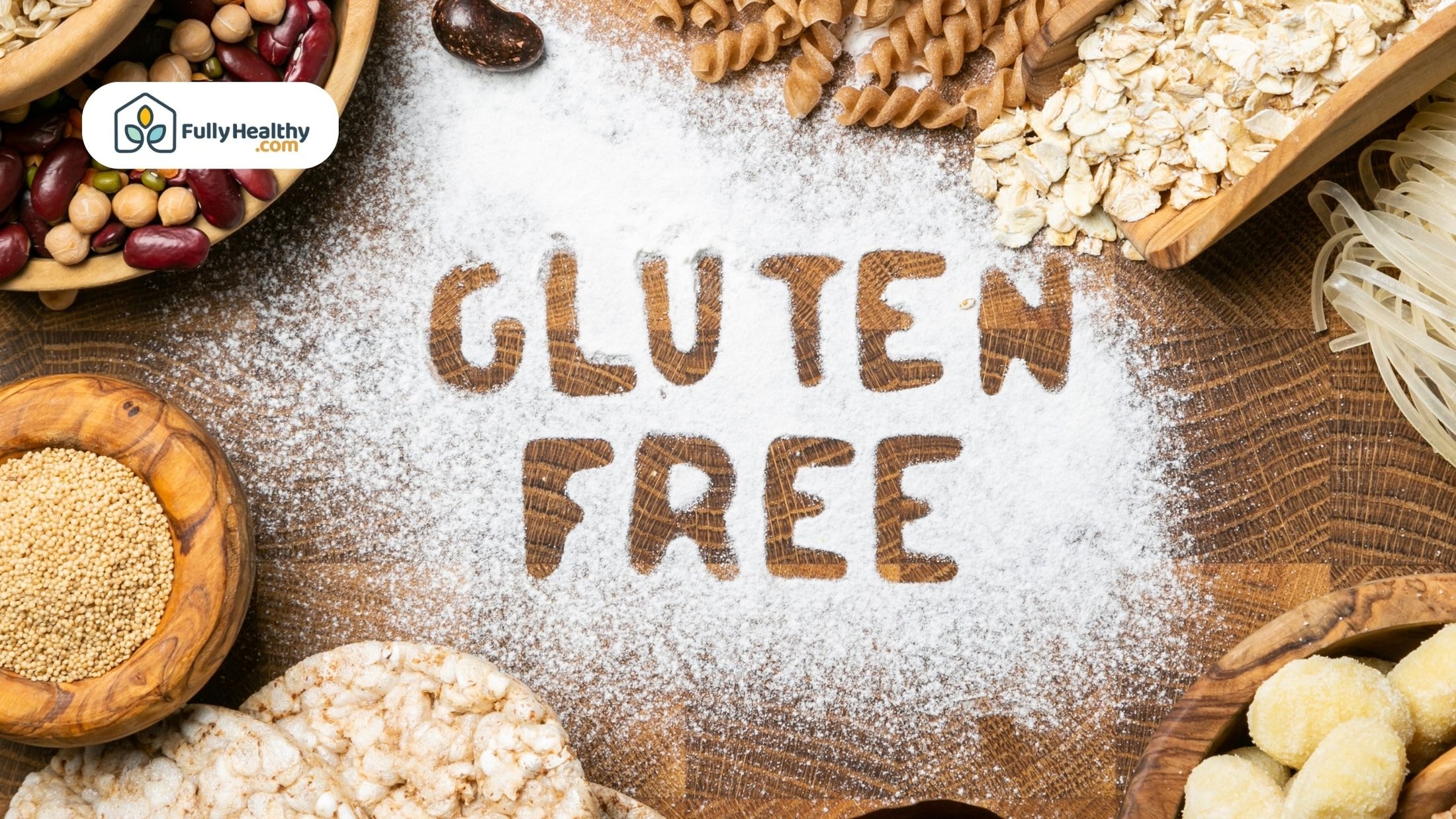 Gluten free ingredients and grains on a table with “GLUTEN FREE” written in flour,