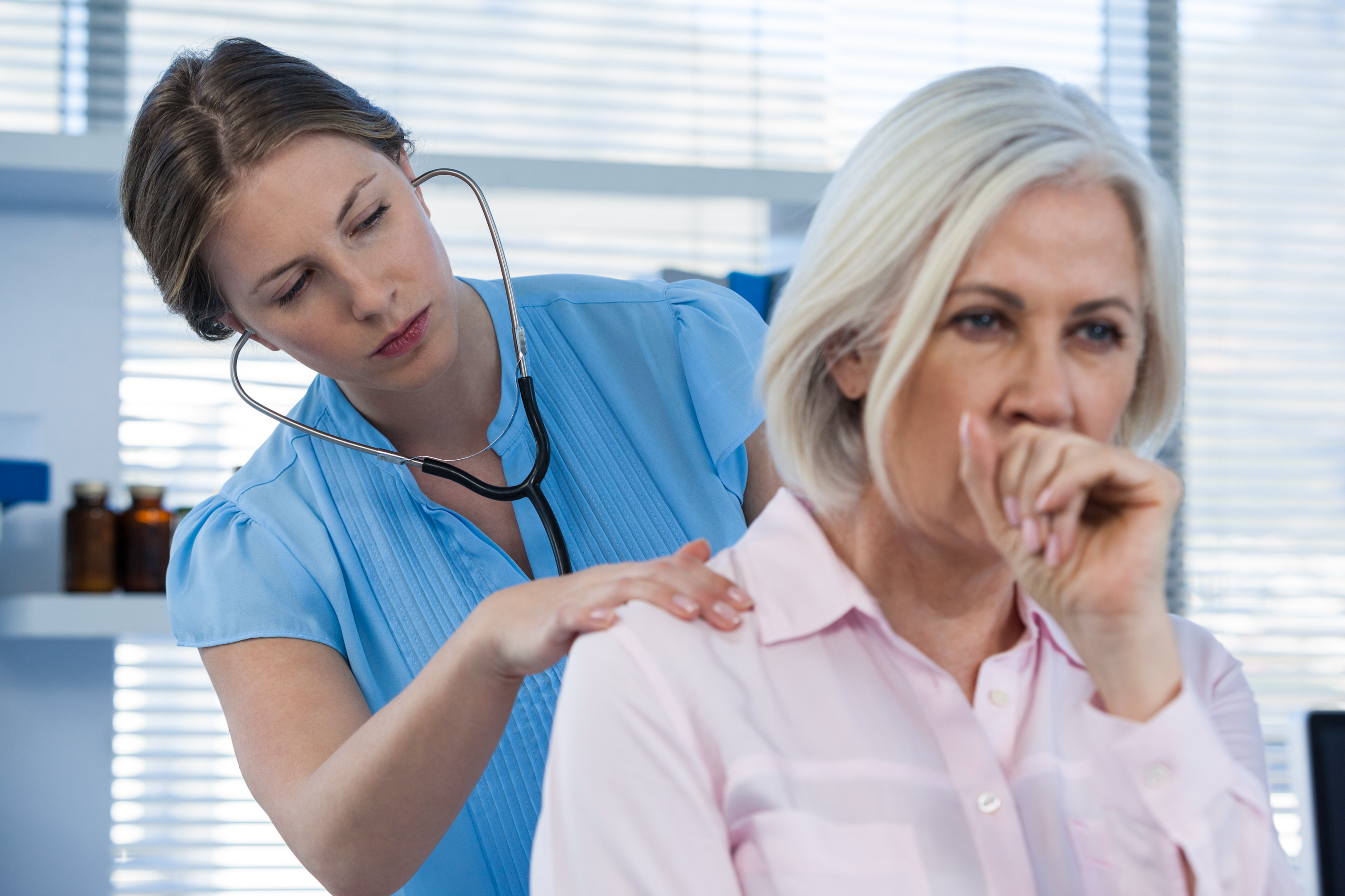 An image of a doctor examining a patient who has trouble swallowing.