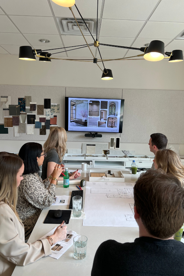 interior designers meeting with clients in a studio to show them mood boards before starting the interior design sourcing process