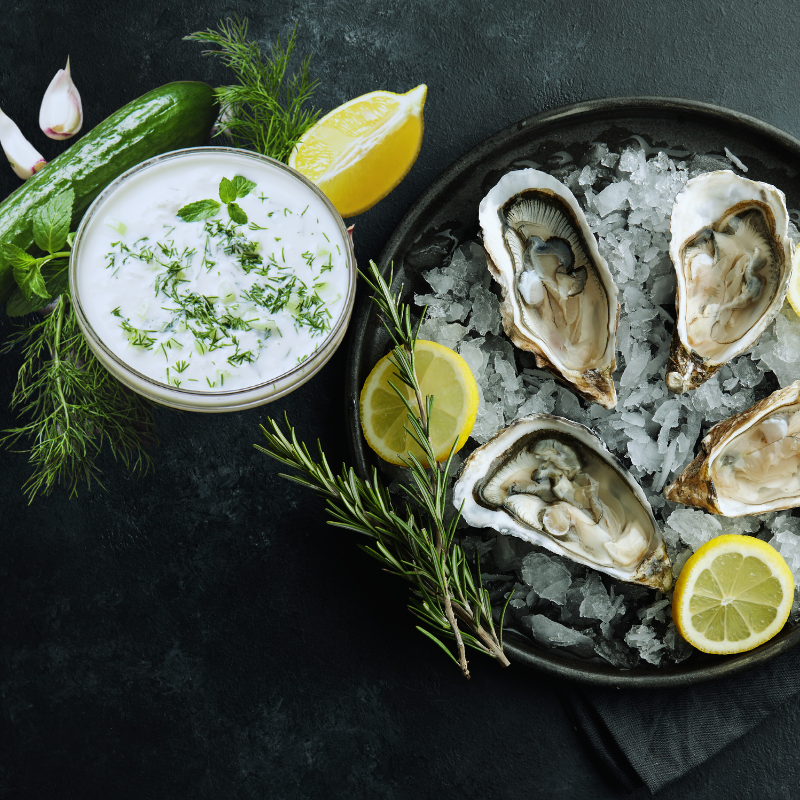 Image illustrating a cucumber dill salad and garlic spinach as a fresh pairing with oysters.