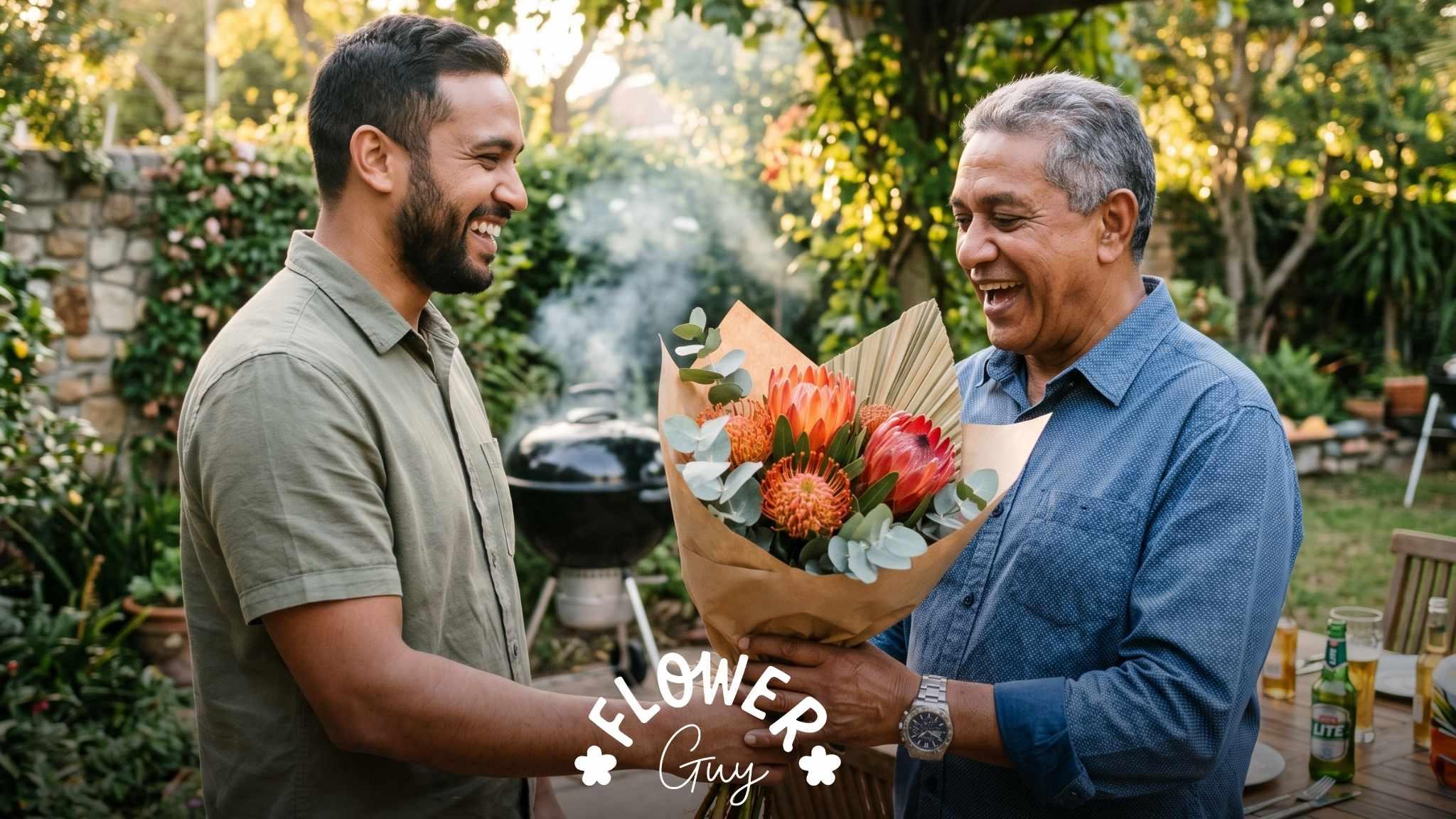 South African son hands his dad a protea bouquet with happy birthday wishes and birthday greetings at a backyard braai in Cape Town