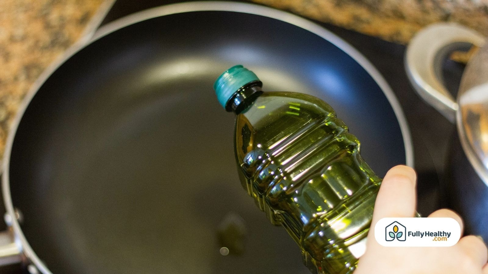 Hand pouring olive oil from bottle into empty frying pan