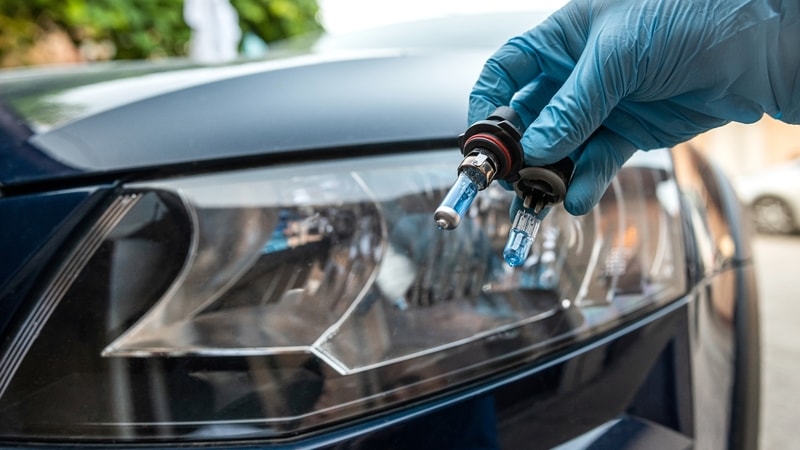 Mechanic replacing car headlight Bulbs