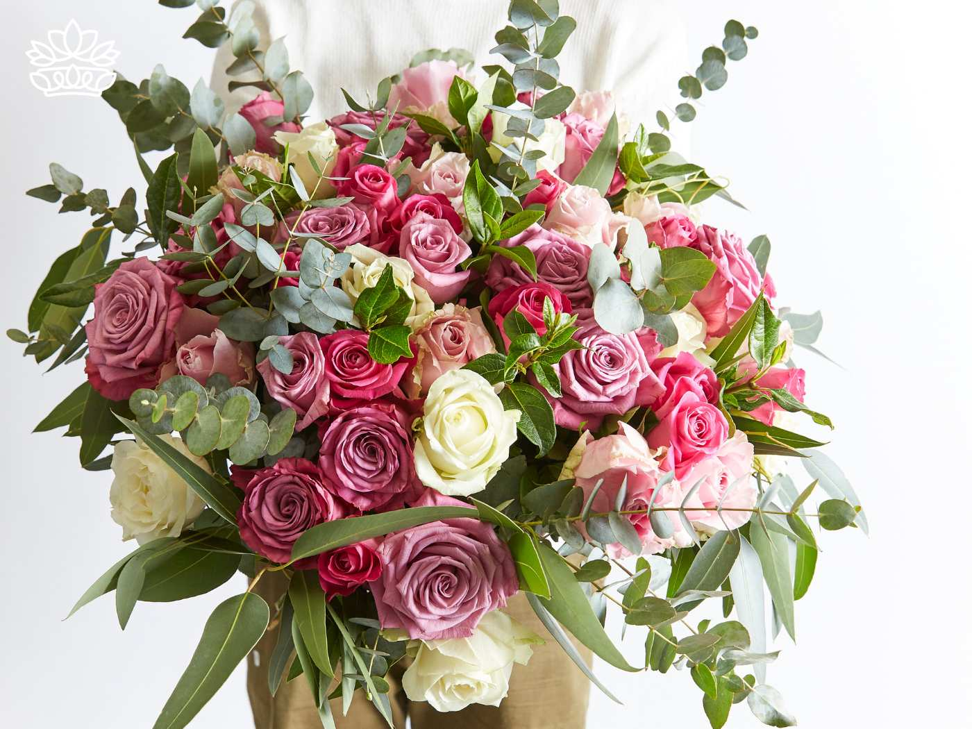 A lush bouquet filled with shades of pink and white roses and accented by eucalyptus and vibrant green leaves, representing elegance and heartfelt gifting. Fabulous Flowers and Gifts. Gifts for Her.