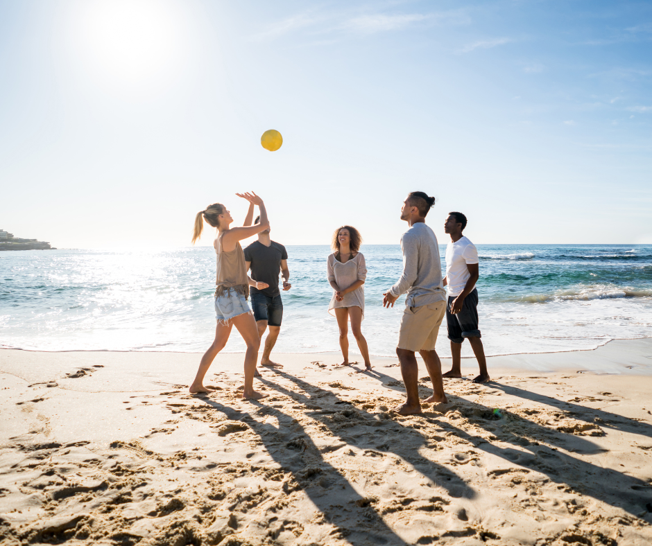 A group of friends playing beach volleyball and having fun without alcohol, promoting have fun without alcohol in physical fitness activities.