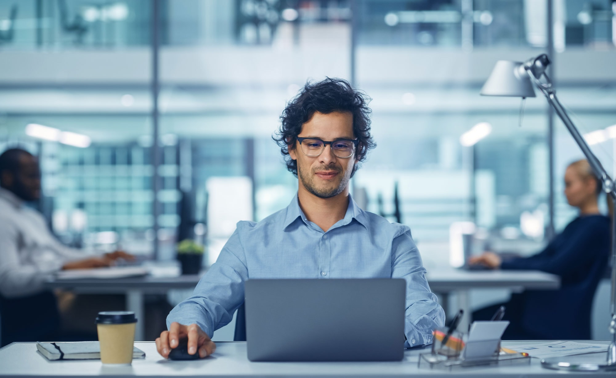 Professional using an insurance agency management system on a laptop in a modern office environment.