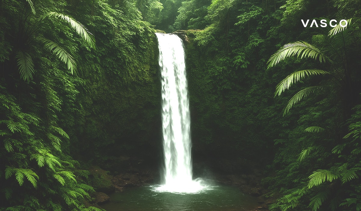 A majestic waterfall cascading into a serene pool in the middle of a dense, green tropical jungle.