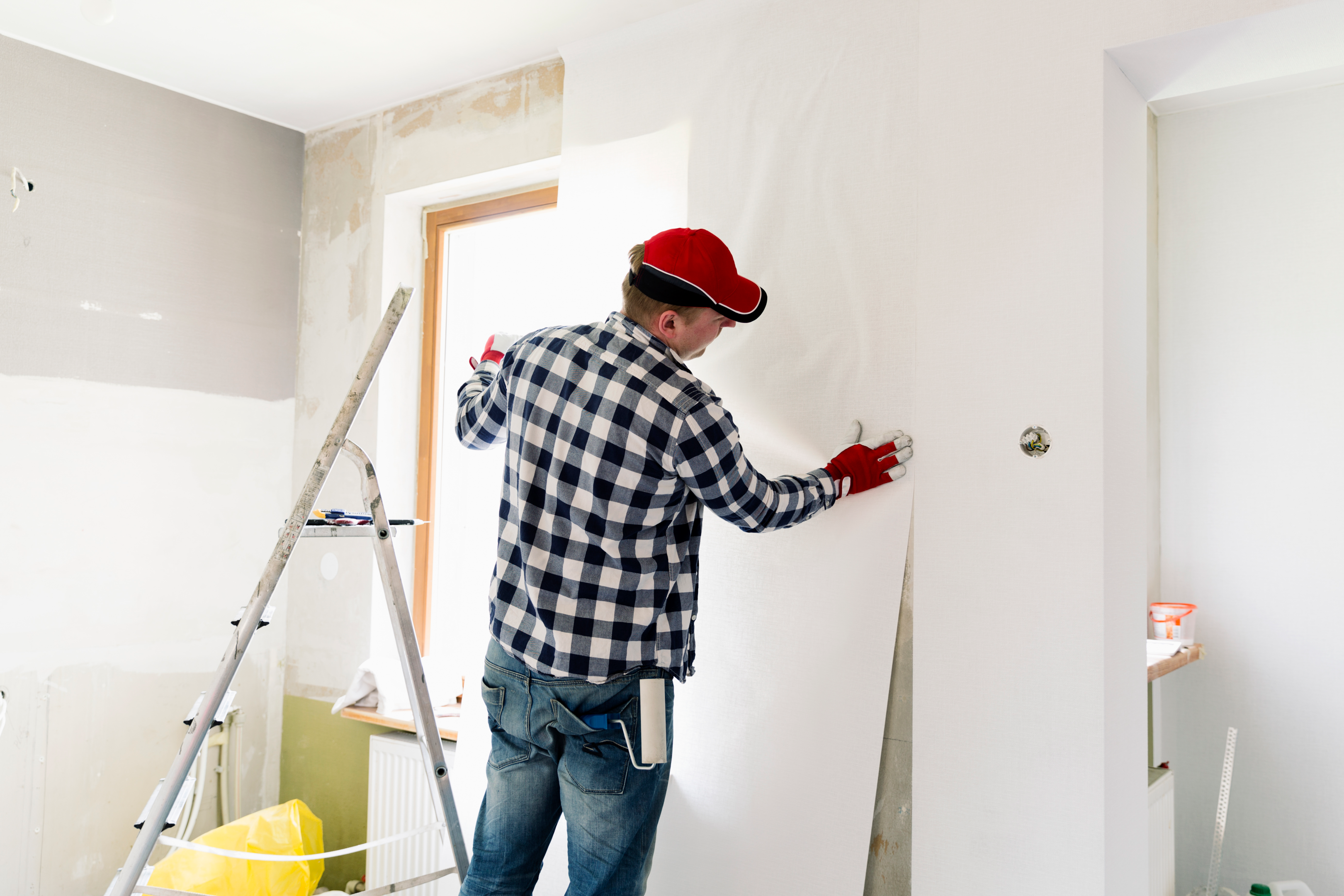Source: artursfoto, iStock, https://www.istockphoto.com/de/foto/paste-wallpaper-at-home-young-man-is-worker-putting-up-wallpaper-on-the-wall-gm954924076- 260729076?phrase=to wallpaper