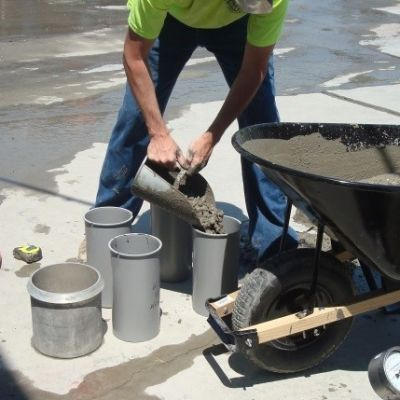 A technician molding a concrete cylinder test specimen
