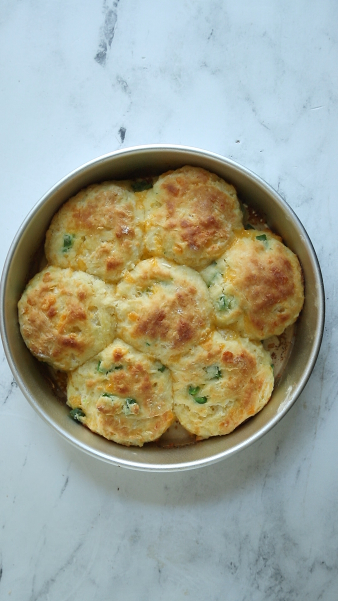 baked cheddar jalapeno biscuits in a round cake pan