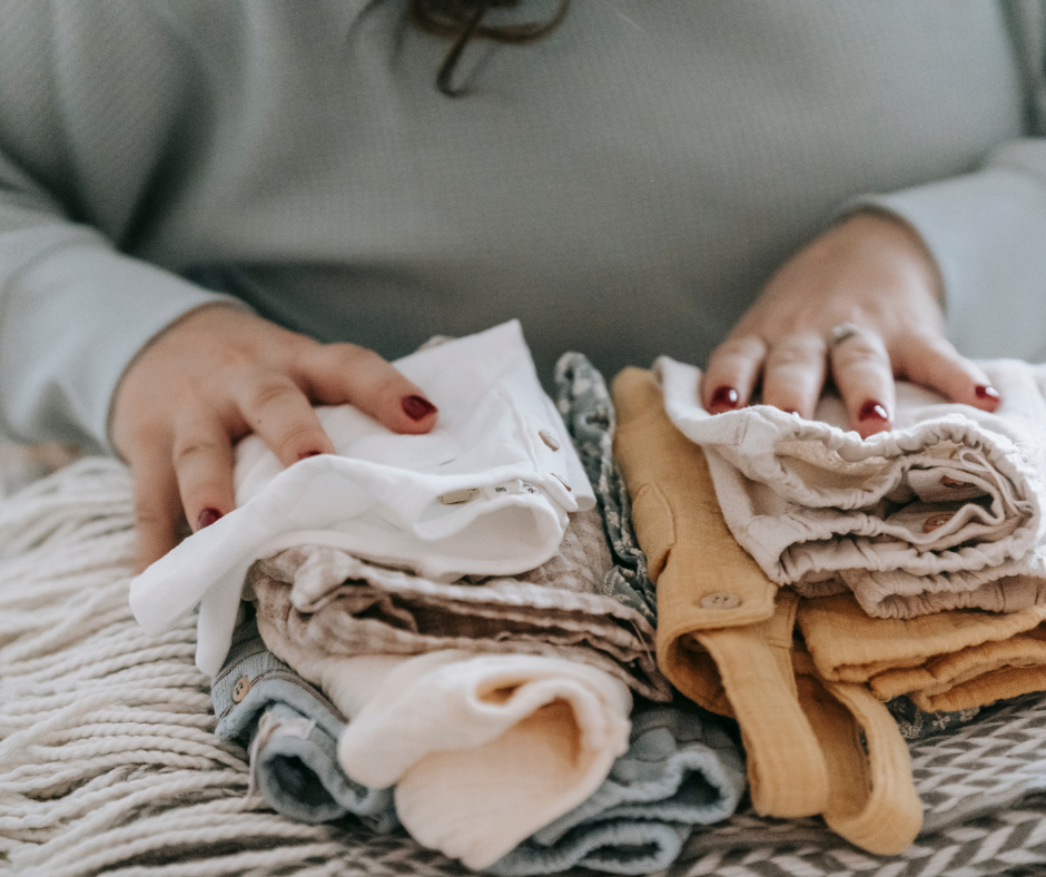 A woman organizing baby clothes so she can properly store clothing