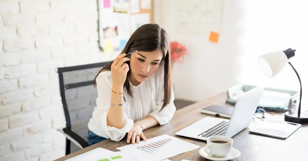 Woman organizing financial records and using audit protection support for OnlyFans taxes.