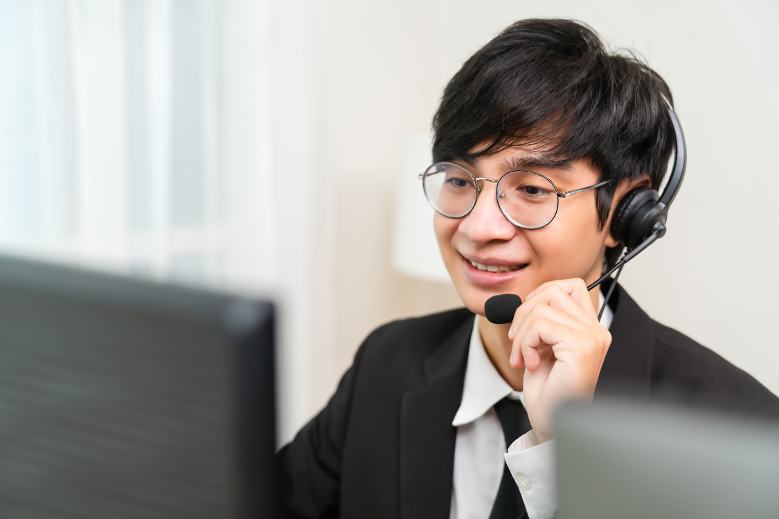 Male customer support VA wearing a headset while speaking to a customer