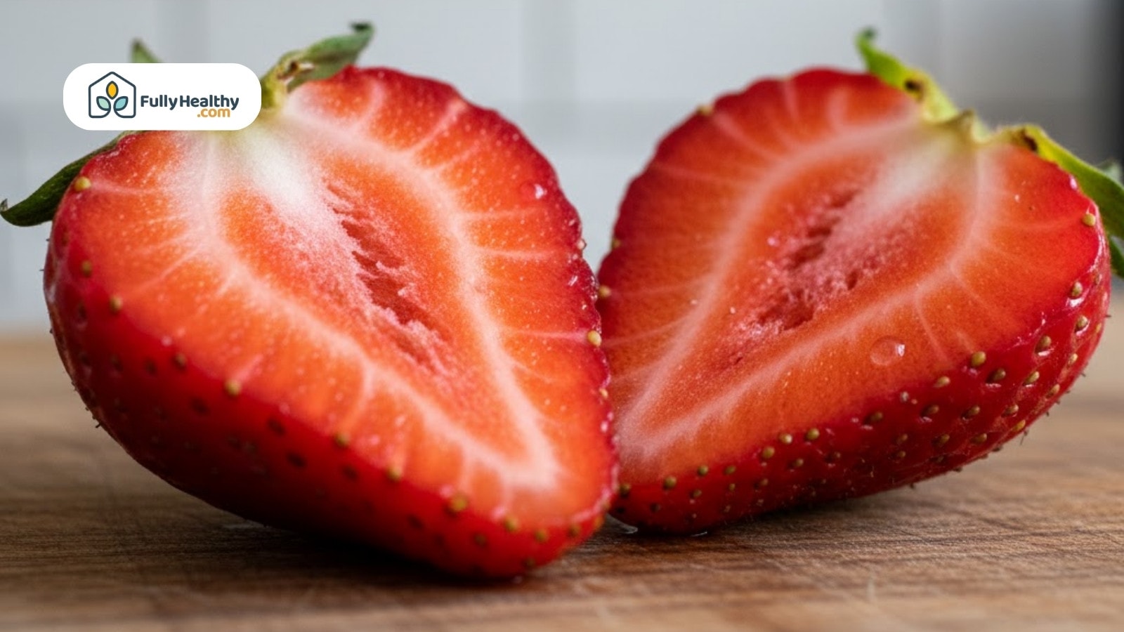 Halved ripe strawberry showing detailed interior texture and seeds on wooden surface