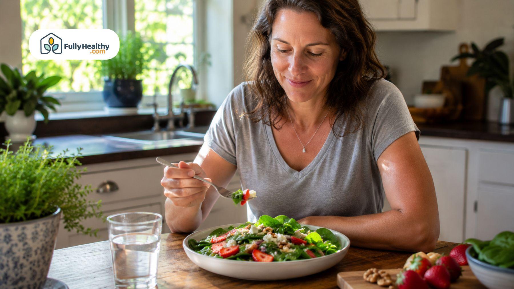 Adult enjoying a fresh spinach salad at a dining table with natural window light.