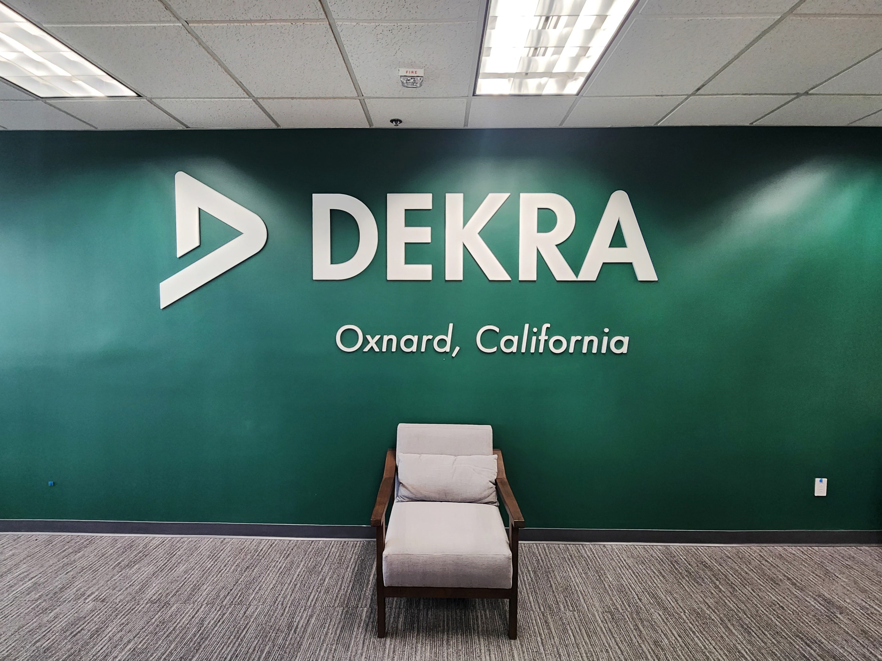 This custom lobby sign for Dekra in Oxnard creates a strong first impression, combining sleek materials and clean design to reflect the company’s professional brand.
