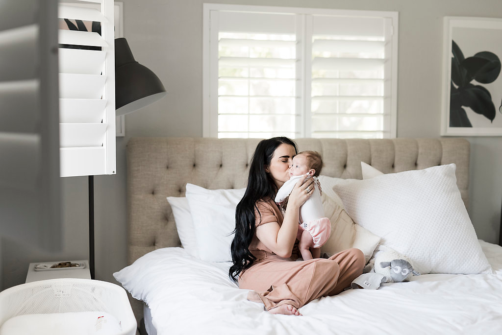 New mom kissing newborn baby girl