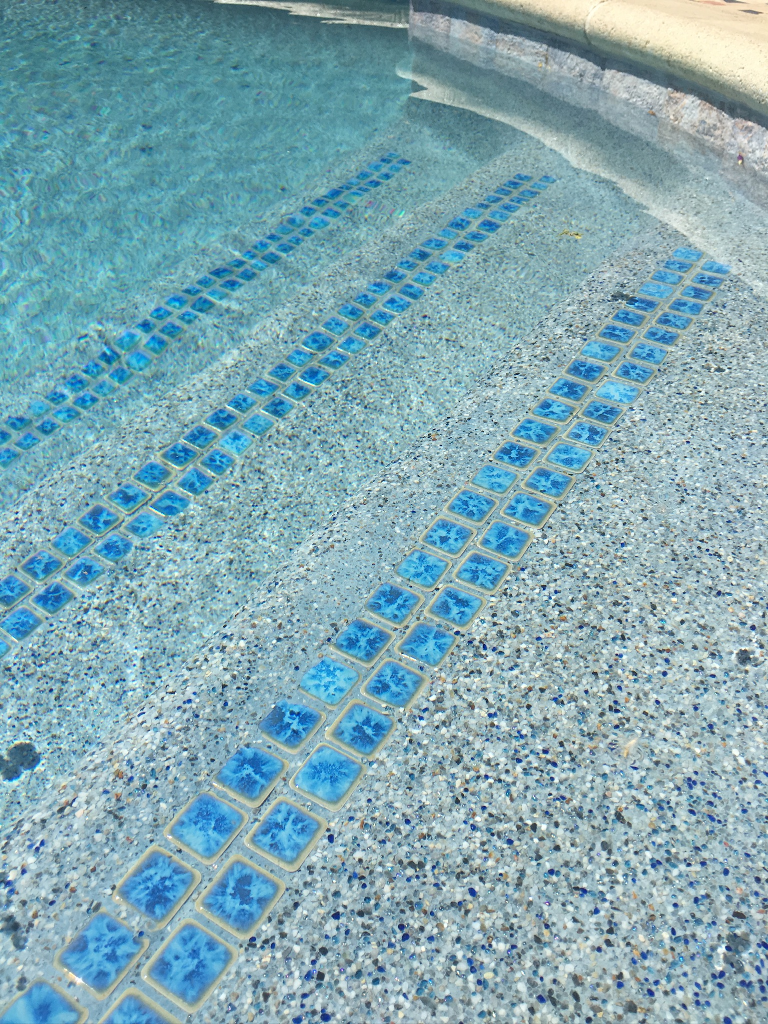A mini pebble finish with tile accents on a swimming pool.