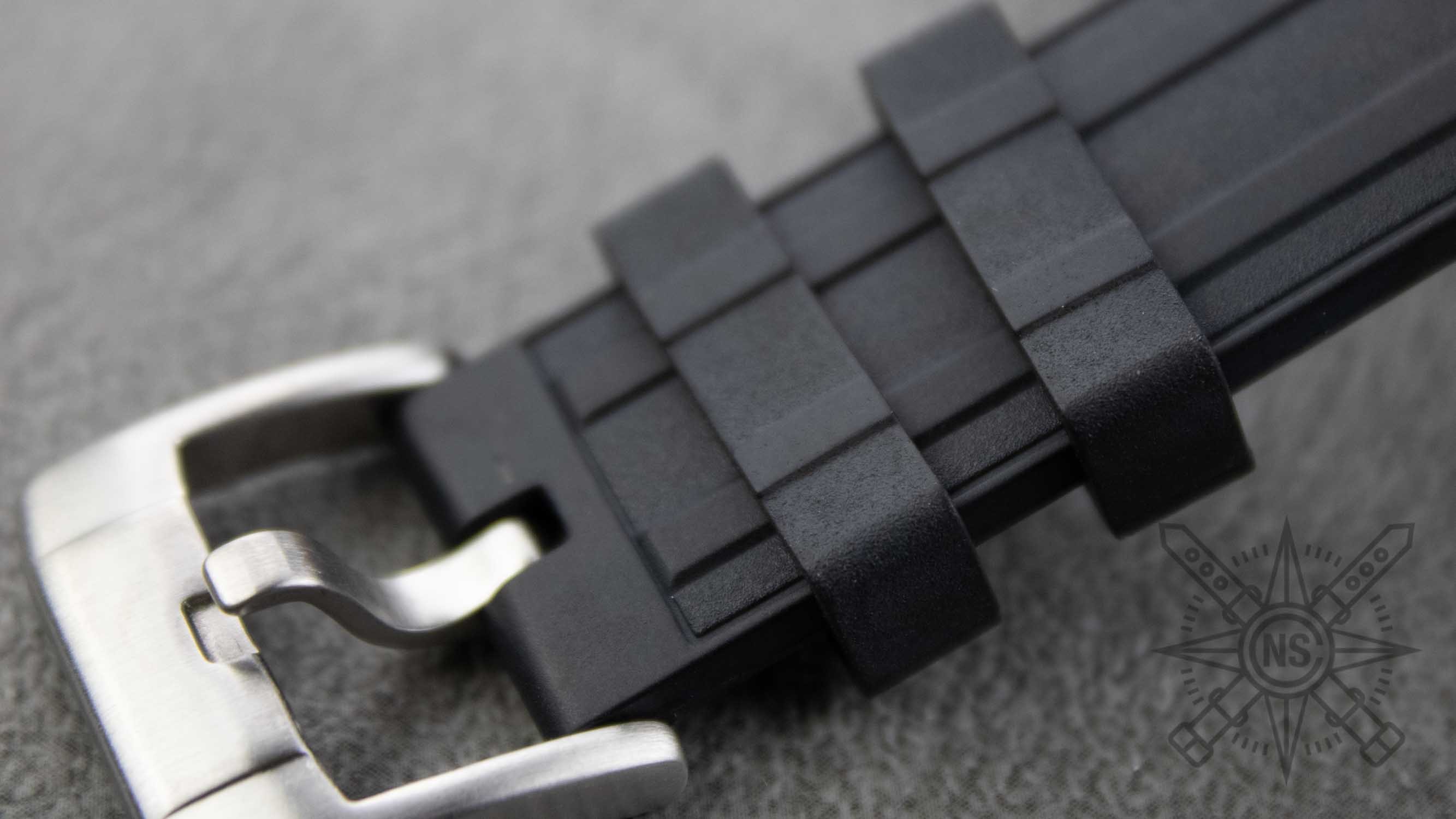 Different types of rubber straps laid out next to a Rolex Submariner, highlighting compatibility.