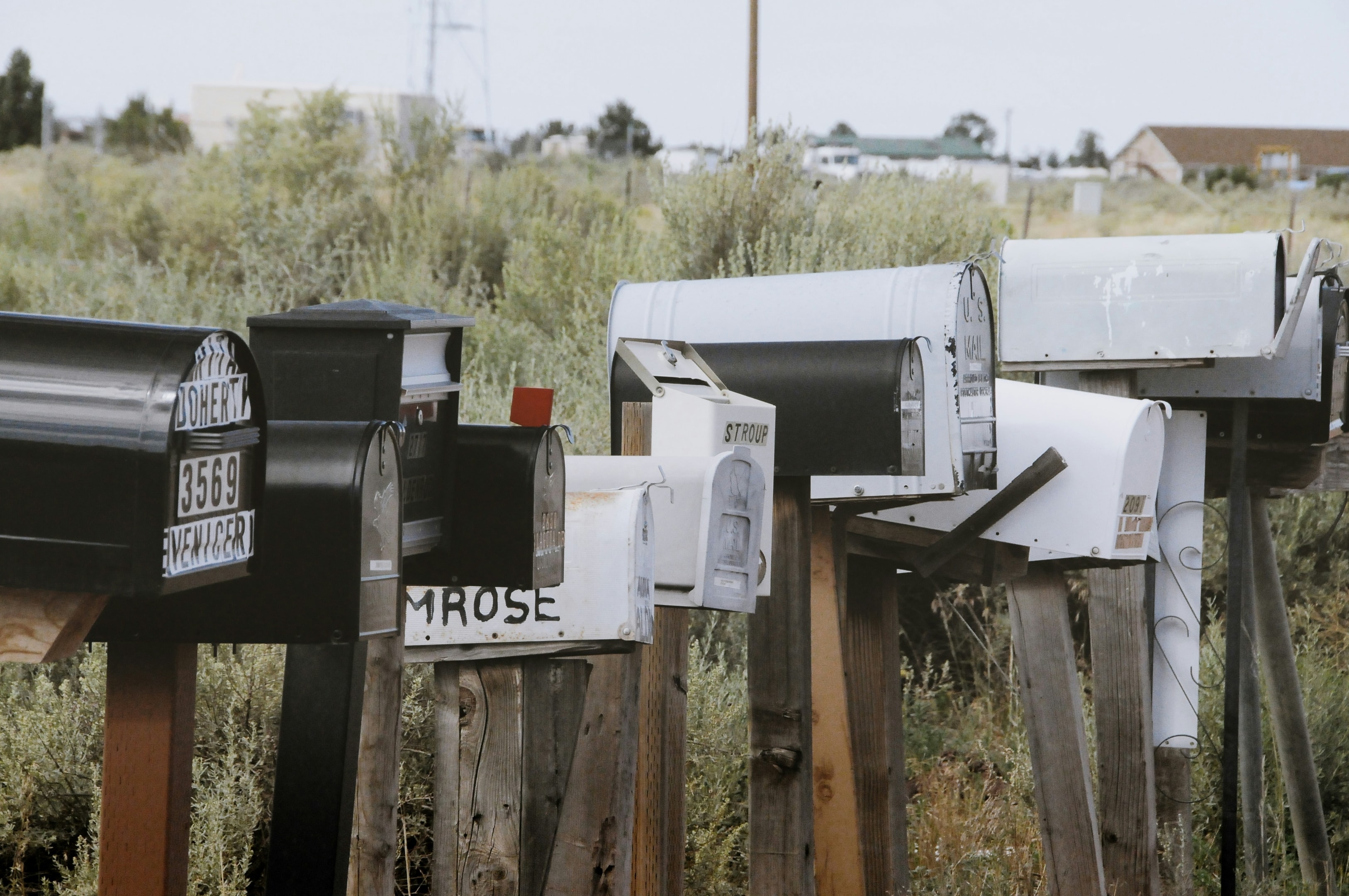 Row of mailboxes in front of multiple homes in a neighborhood. 